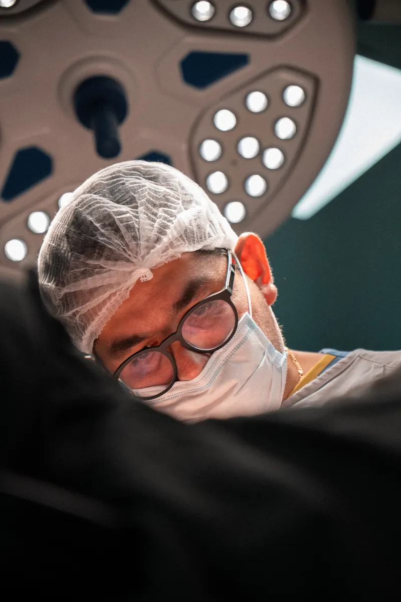 Dr. John Terrazas concentrado no campo cirúrgico
