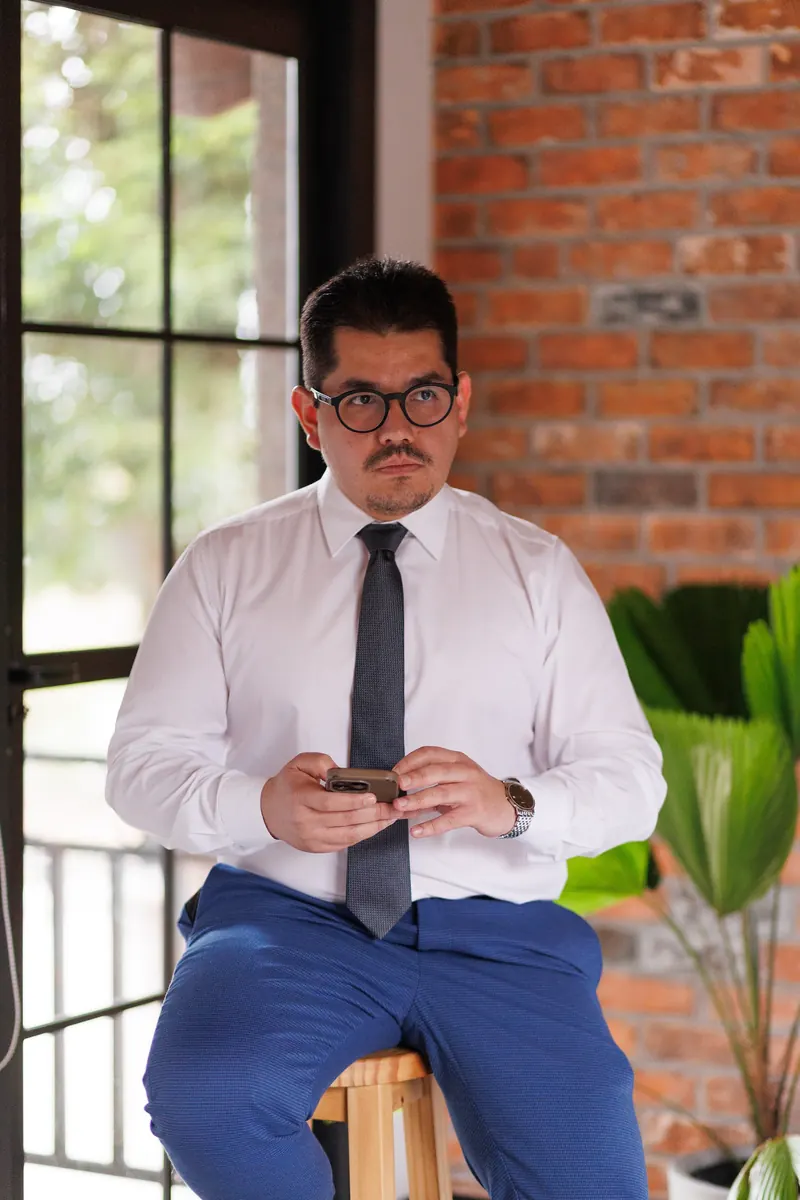 Dr. John Terrazas sentado, com o celular nas mãos